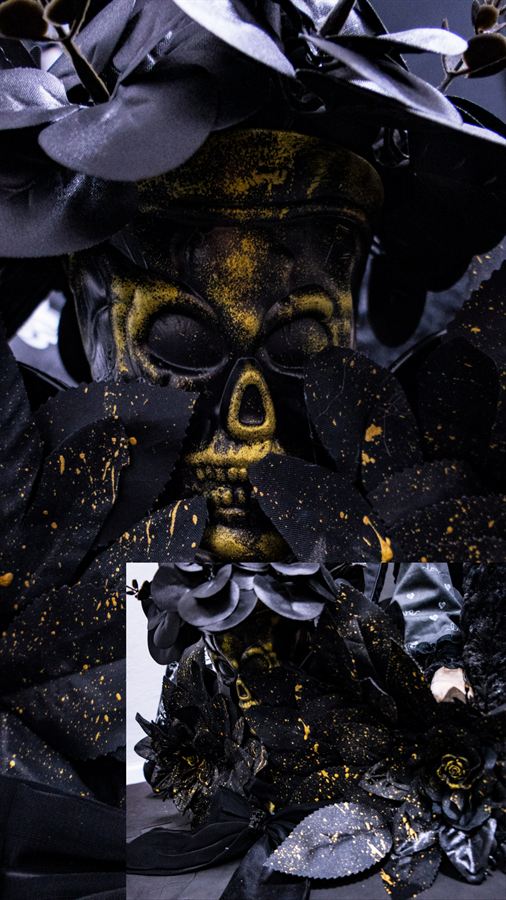 Totenkopf umgeben von schwarzen Blättern und Blüten mit Goldsprenkeln