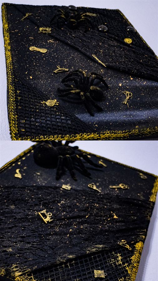 Schwarze Textilarbeit mit Goldborte, Spinne und kleinen Nähwerkzeug-Anhängern