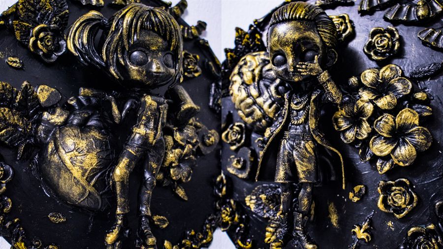 Zwei Reliefs mit Figuren zwischen Blüten und Herz, schwarz mit Gold